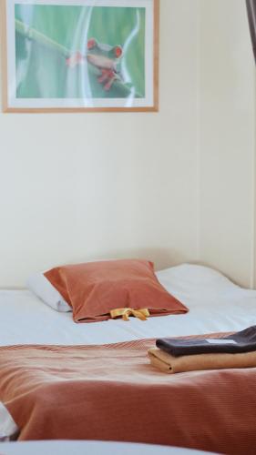 a bed with a red pillow and a picture on the wall at Hostelli Marja in Mikkeli