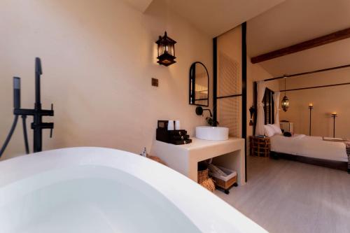 a bathroom with a bed and a sink and a mirror at M ORIGINAL VILLA in Jinghong