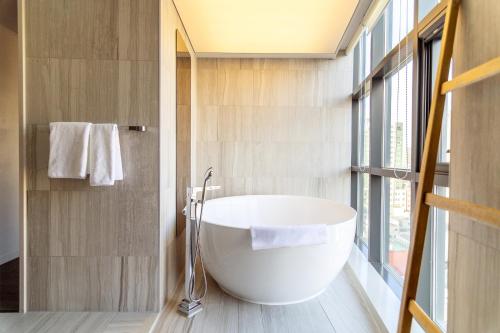 a bathroom with a large white tub in a room at HOMES Red Myeongdong in Seoul