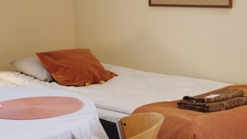 a room with a bed with a pillow and a chair at Hostelli Marja in Mikkeli