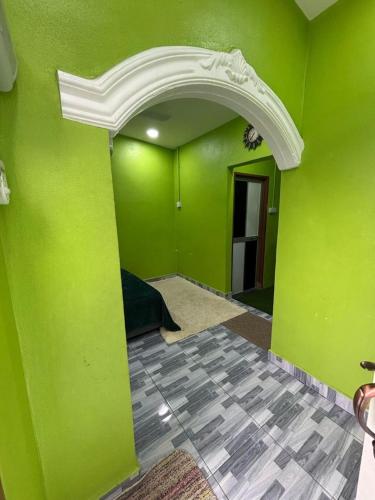 an empty room with green walls and an archway at Siti Roomstay Langkawi in Gua Sai