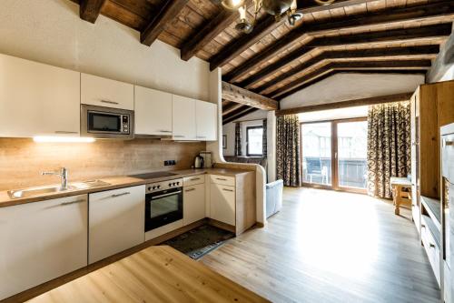 a kitchen with white cabinets and a large window at Appartementanlage Kerber in Seefeld in Tirol