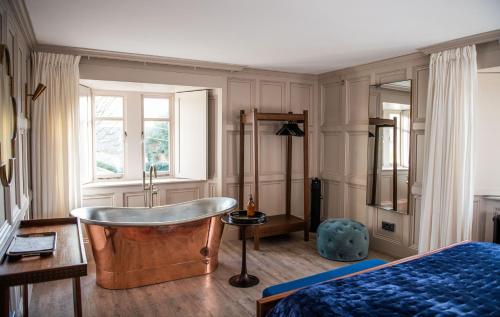 a bedroom with a tub and a bed and a window at Chapel House Estate in Kent