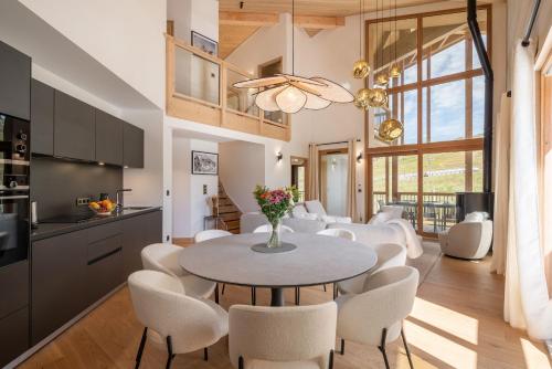 una cucina e una sala da pranzo con tavolo e sedie di Apartment Nivalis Alpe D'Huez - by EMERALD STAY a LʼHuez
