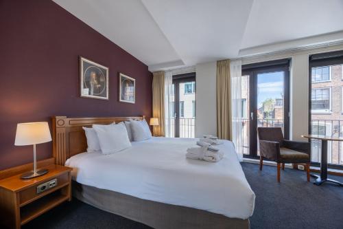 a hotel room with a bed with a teddy bear on it at Amrâth Grand Hotel Frans Hals in Haarlem