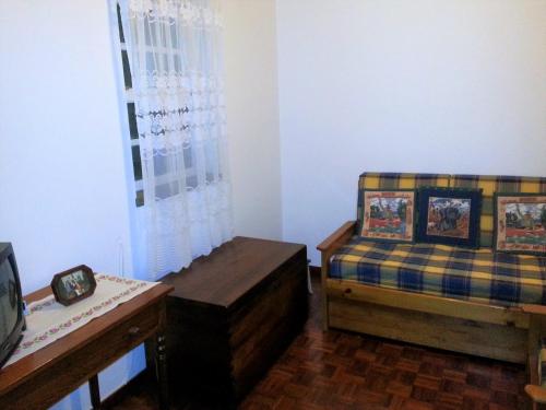 Habitación con cama, sofá y mesa. en House Andrade, en Praia do Norte