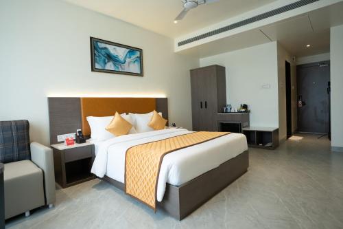 a bedroom with a large bed and a chair at ZiP By Spree Hotels Pandharpur in Pandharpur