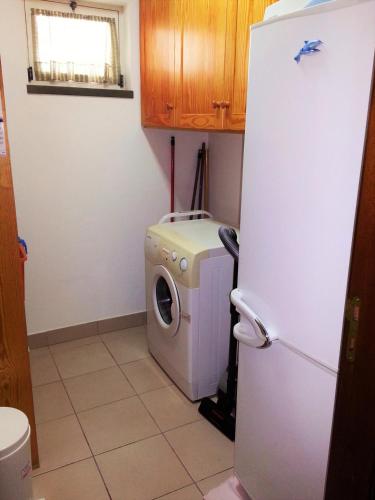 a kitchen with a washing machine and a refrigerator at House Andrade in Praia do Norte