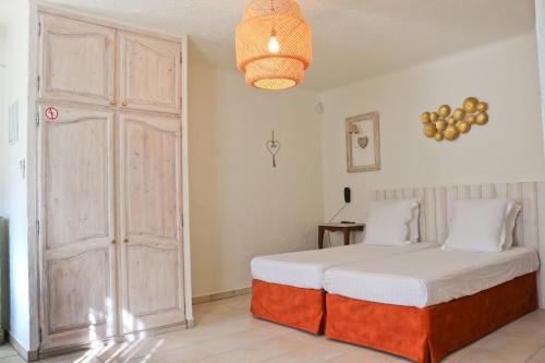 a bedroom with a white bed and a door at La Villa Roseraie , Hôtel Familial OUVERT TOUTE L'ANNEE in Vence