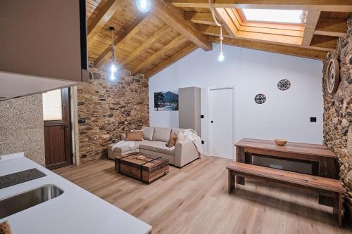 a living room with a couch and a table at As casiñas da Figueira by Serendipia Turismo in Pobra do Caramiñal