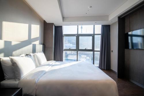 a bedroom with a large bed and a large window at HOMES Red Myeongdong in Seoul