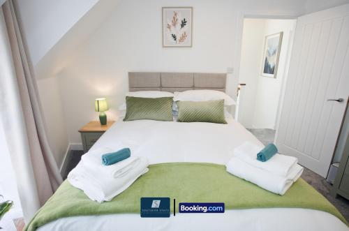 a bedroom with a large white bed with towels on it at 2 Bed House By Southern Stays Short Lets & Serviced Accommodation Bournemouth With Parking - Relocation & Family, 1km From The Beach in Bournemouth