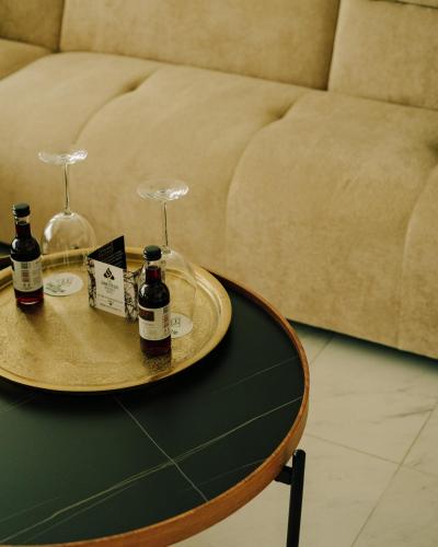 a table with two wine glasses and a tray with wine bottles at The Ciao Stelio Deluxe Boutique Hotel - Adults Only in Larnaka