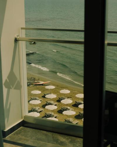 a view of a beach with umbrellas from a window at The Ciao Stelio Deluxe Boutique Hotel - Adults Only in Larnaka