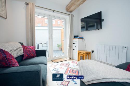 a living room with a couch and a sliding glass door at 2 Bed House By Southern Stays Short Lets & Serviced Accommodation Bournemouth With Parking - Relocation & Family, 1km From The Beach in Bournemouth