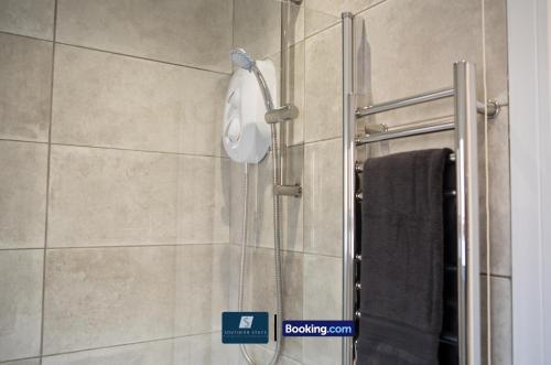 a shower with a shower head in a bathroom at 2 Bed House By Southern Stays Short Lets & Serviced Accommodation Bournemouth With Parking - Relocation & Family, 1km From The Beach in Bournemouth