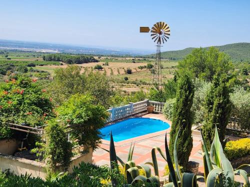 a swimming pool in a garden with a windmill at La Muntanera - Eco-friendly apartment in Figuerola