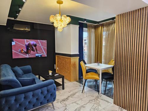 Una sala de estar con un sofá azul y una mesa. en Luxury Continental two rooms, en Sofía