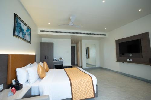 a bedroom with a large bed and a flat screen tv at ZiP By Spree Hotels Pandharpur in Pandharpur