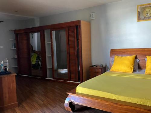 a bedroom with a bed with yellow pillows at Villa Soazara in Koungou