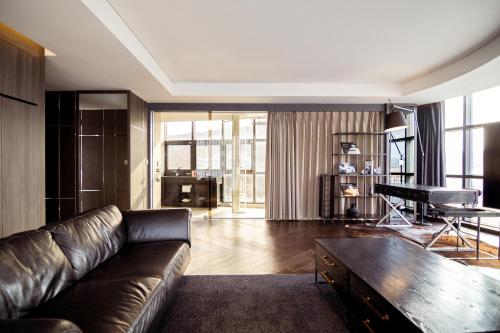 a living room with a leather couch and a piano at HOMES Red Myeongdong in Seoul