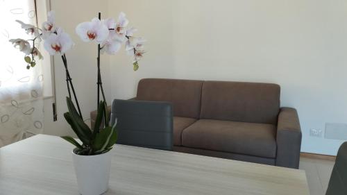 a living room with a couch and a table with flowers at Sole e Luna in San Vito