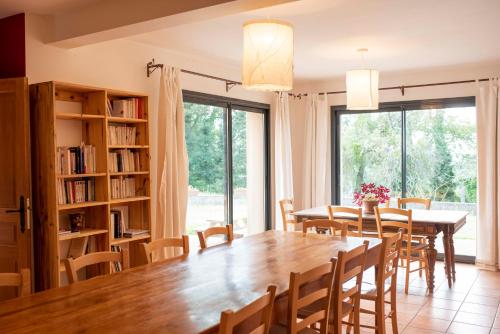 een eetkamer met een grote houten tafel en stoelen bij La Hulotte in Saint-Malon-sur-Mel
