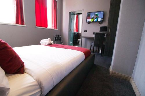 a hotel room with a bed and a television at The Bryson Hotel in London