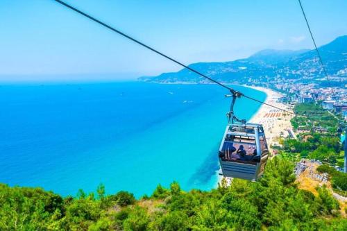a gondola ride over the ocean on a mountain at A dream house with a dream view in ROYAL PARK in Alanya