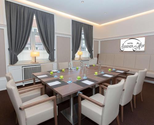 a dining room with a long table and white chairs at Hotel Essener Hof; Sure Hotel Collection by Best Western in Essen