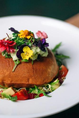 a sandwich on a white plate with flowers on it at Sheraton Sharjah Beach Resort and Spa in Sharjah