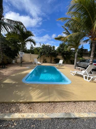 a swimming pool on a concrete floor with palm trees at Pointe Aux Biches Villa in Pointe aux Biches