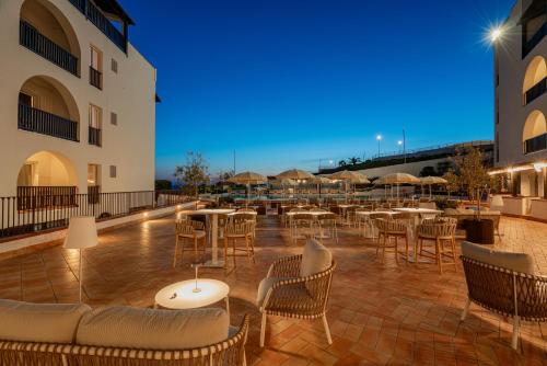 a restaurant with tables and chairs on a patio at Hotel Calabona in Alghero