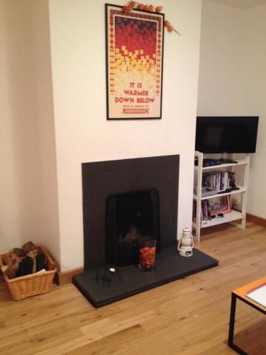 a living room with a fireplace with a picture on the wall at Galway City Self Catering - Salthill in Galway