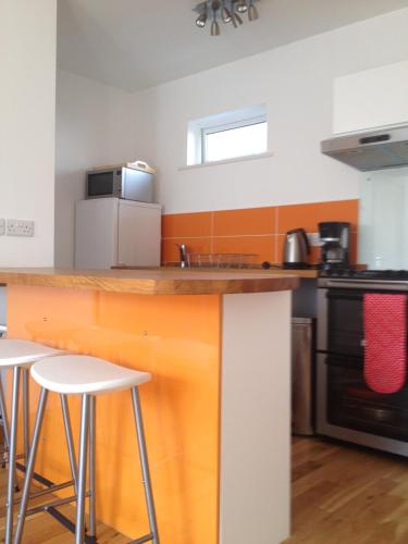 a kitchen with a counter and stools in it at Galway City Self Catering - Salthill in Galway