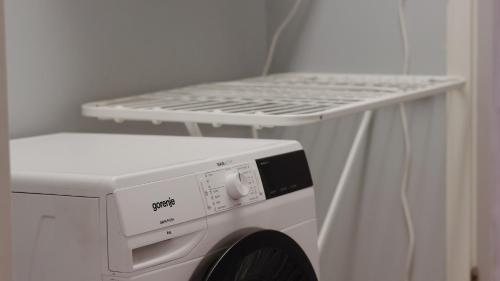 a white washing machine with a shelf on top of it at Hostelli Marja in Mikkeli