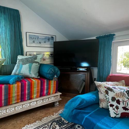 un salon avec un canapé et une télévision à écran plat dans l'établissement LeLoft au dessus des Pins, à Lacanau