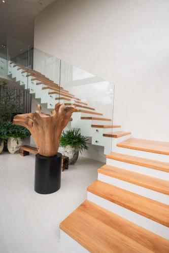 a staircase in a house with a tree sculpture at Mahutsachan Khlong Thom in Krabi town
