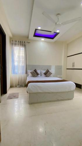 a bedroom with a large bed with a blue light at Cassava Stay in New Delhi