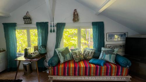 sala de estar con sofá y almohadas coloridas en LeLoft au dessus des Pins, en Lacanau