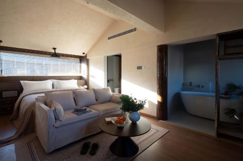 a living room with a couch and a bed and a table at Shuxia · Summer Lijiang Baisha Snow Mountain Scenic Hotel in Baisha