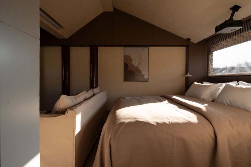 a bedroom with a large bed and a window at Shuxia · Summer Lijiang Baisha Snow Mountain Scenic Hotel in Baisha