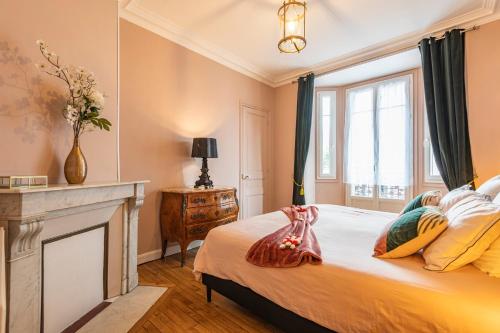 a bedroom with a large bed with a fireplace at Le Louis XV Halte à Reims centre in Reims