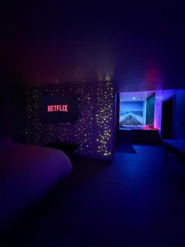 a dark room with a netflix sign on a wall at L'Évasion des Sens - Spa Sauna Hammam Jacuzzi in Bray-sur-Somme
