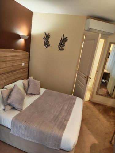 a bedroom with a bed with two leaves on the wall at Logis Hôtel Auberge de la Rose in Doué-la-Fontaine