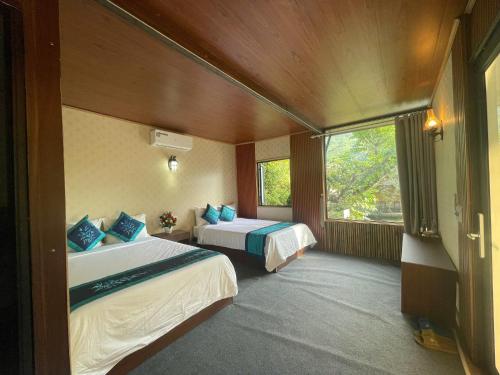 a hotel room with two beds and a window at Sapa Bamboo Eco in Sa Pa