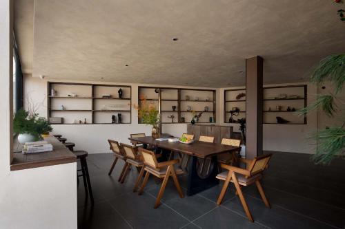 a dining room with a table and chairs and shelves at Shuxia · Summer Lijiang Baisha Snow Mountain Scenic Hotel in Baisha