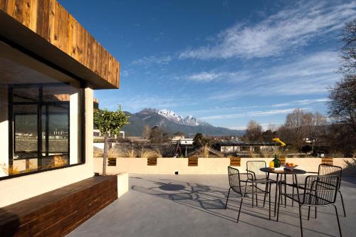 a patio with a table and chairs and a mountain at Shuxia · Summer Lijiang Baisha Snow Mountain Scenic Hotel in Baisha