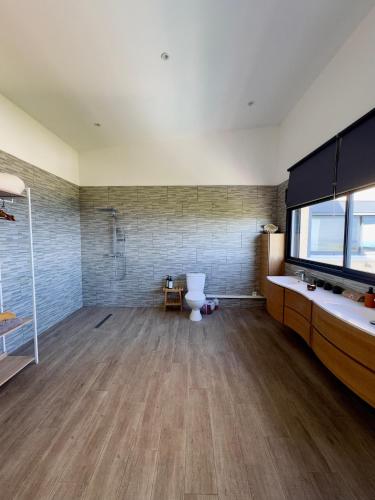 a bathroom with a toilet and a large window at La Villa Des Oliviers chambres d hôtes in Petite Île