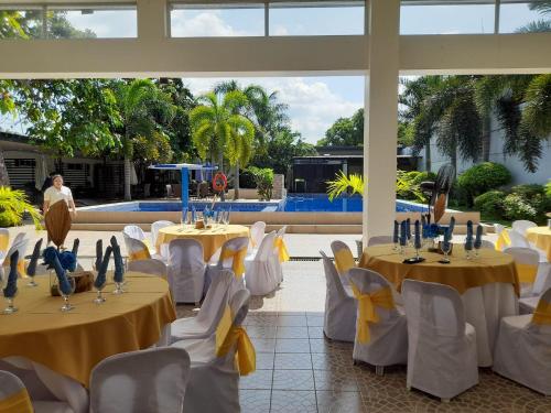 ein Bankettsaal mit Tischen und Stühlen mit gelben Tischdecken in der Unterkunft Villa Angelica Private Resort and Venue in San Juan